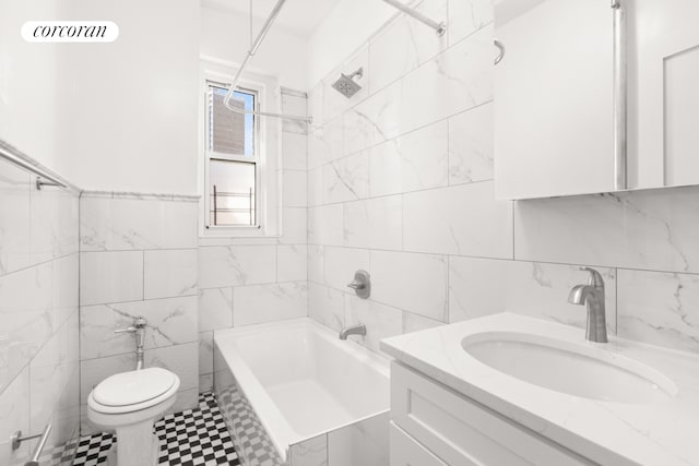 bathroom featuring tile patterned floors, shower / bathing tub combination, vanity, tile walls, and toilet