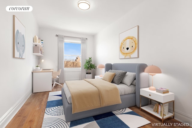 bedroom with baseboards, wood finished floors, and visible vents