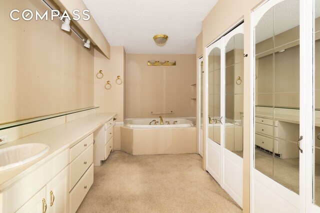 20 W 64th St Unit 41H, New York City, NY 10023 - bathroom with a garden tub, a shower with door, vanity, and carpet