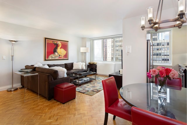 living room featuring baseboards, a chandelier, and a wealth of natural light