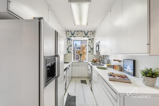 1050 5th Ave Unit 17D, New York City, NY 10028 - kitchen with fridge with ice dispenser, range with gas stovetop, light countertops, stainless steel microwave, and white cabinets
