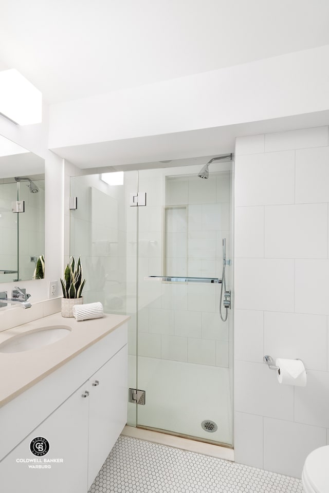bathroom featuring a shower stall, vanity, toilet, and tile patterned flooring