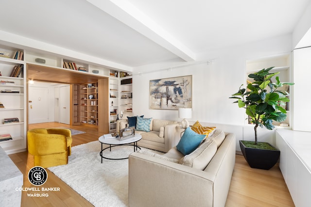 living area featuring light wood-type flooring and beam ceiling