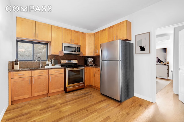 34-57 9th St, New York City, NY 11106 - kitchen with appliances with stainless steel finishes, light wood-style flooring, decorative backsplash, and dark stone countertops