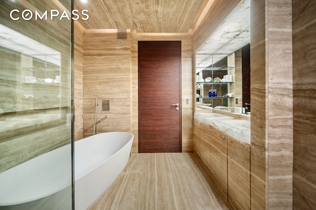 full bathroom featuring a freestanding bath, wooden ceiling, and vanity
