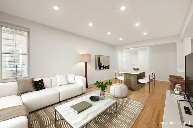 living room with recessed lighting, light wood-style flooring, and baseboards