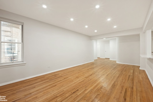 unfurnished room featuring recessed lighting, light wood finished floors, and baseboards