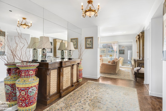 interior space with baseboards, wood finished floors, and a notable chandelier