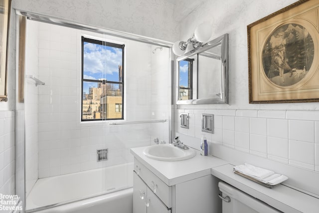 bathroom with tile walls, backsplash, vanity, and  shower combination