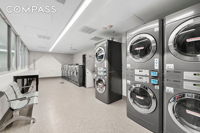 135 W 70th St Unit 8A, New York City, NY 10023 - community laundry room featuring stacked washer / dryer, washing machine and clothes dryer, and baseboards
