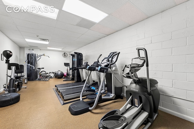 135 W 70th St Unit 8A, New York City, NY 10023 - exercise room with a drop ceiling, concrete block wall, and baseboards