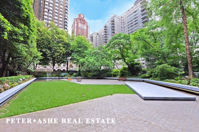 surrounding community with a lawn and a view of city