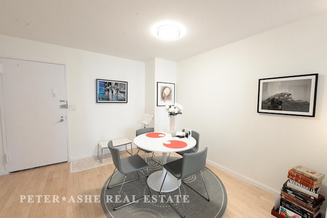dining area with baseboards and light wood finished floors