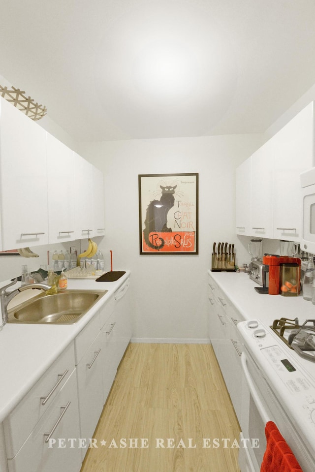 kitchen with a sink, light wood finished floors, light countertops, white cabinets, and white range with gas cooktop