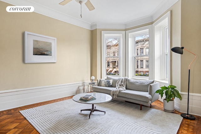 sitting room with a ceiling fan, ornamental molding, and visible vents