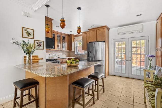 253 21st St, New York City, NY 11215 - kitchen with stainless steel appliances, a wall unit AC, a peninsula, brown cabinetry, and a kitchen breakfast bar