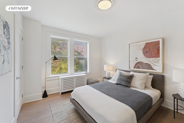 148-09 Northern Blvd Unit 6L, New York City, NY 11354 - bedroom featuring wood finished floors, baseboards, and radiator heating unit