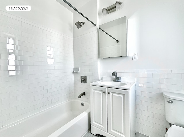 148-09 Northern Blvd Unit 6L, New York City, NY 11354 - bathroom featuring toilet, tile walls, vanity, washtub / shower combination, and wainscoting