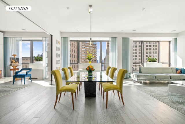 dining space featuring visible vents, wood finished floors, and a healthy amount of sunlight