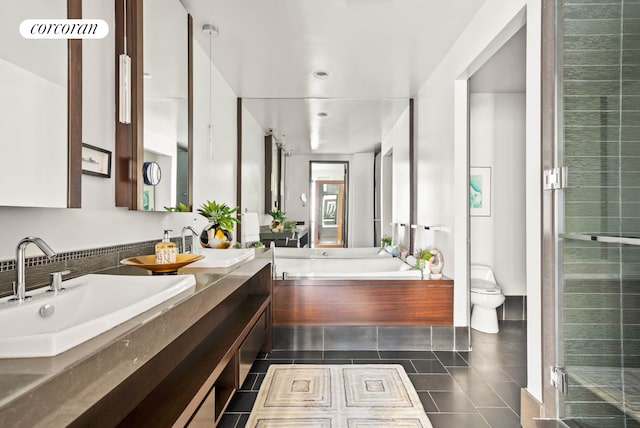 bathroom featuring a sink, a bath, tile patterned floors, and toilet