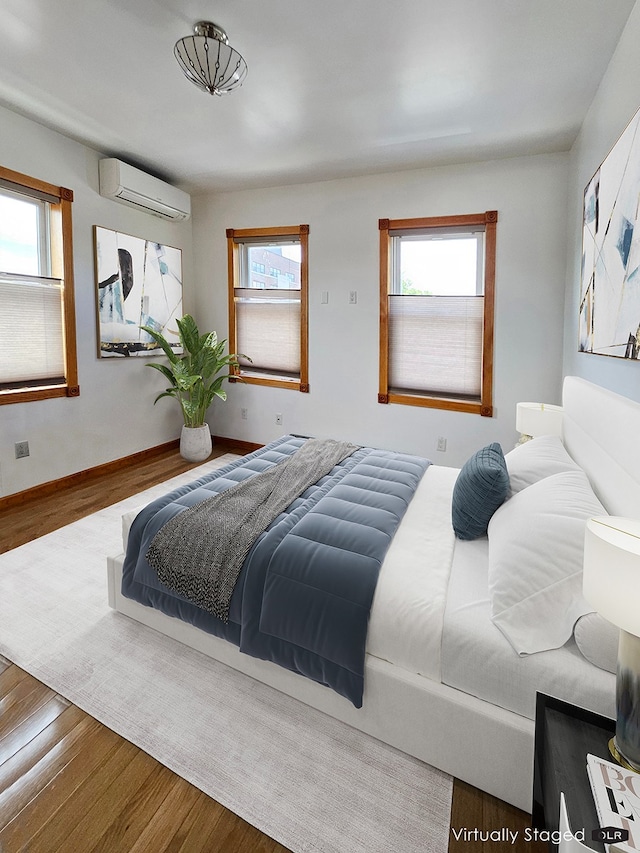 230 26th St, New York City, NY 11232 - bedroom with an AC wall unit, wood finished floors, multiple windows, and baseboards