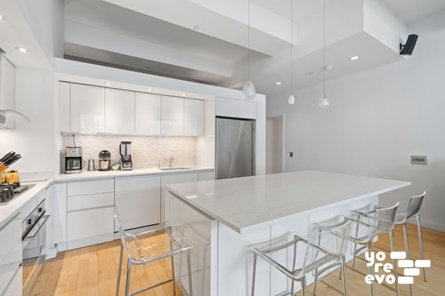 15 Broad St Unit 2714, New York City, NY 10005 - kitchen with stainless steel appliances, modern cabinets, white cabinets, light wood-type flooring, and recessed lighting
