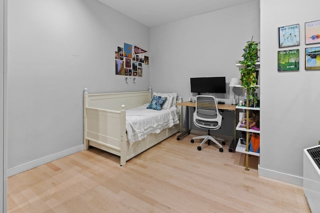 bedroom with baseboards and wood finished floors