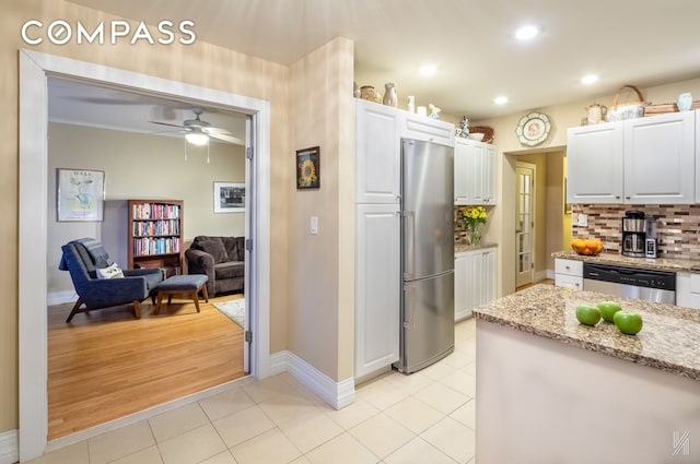 34-41 85th St Unit 4P, New York City, NY 11372 - kitchen with appliances with stainless steel finishes, white cabinets, light stone countertops, light tile patterned floors, and recessed lighting