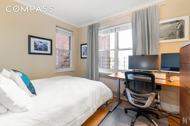 34-41 85th St Unit 4P, New York City, NY 11372 - bedroom featuring wood finished floors, an office area, and radiator heating unit