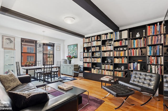 living area featuring beamed ceiling and wood finished floors