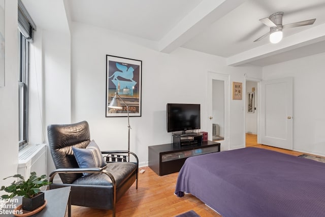bedroom with beamed ceiling, light wood-type flooring, and a ceiling fan
