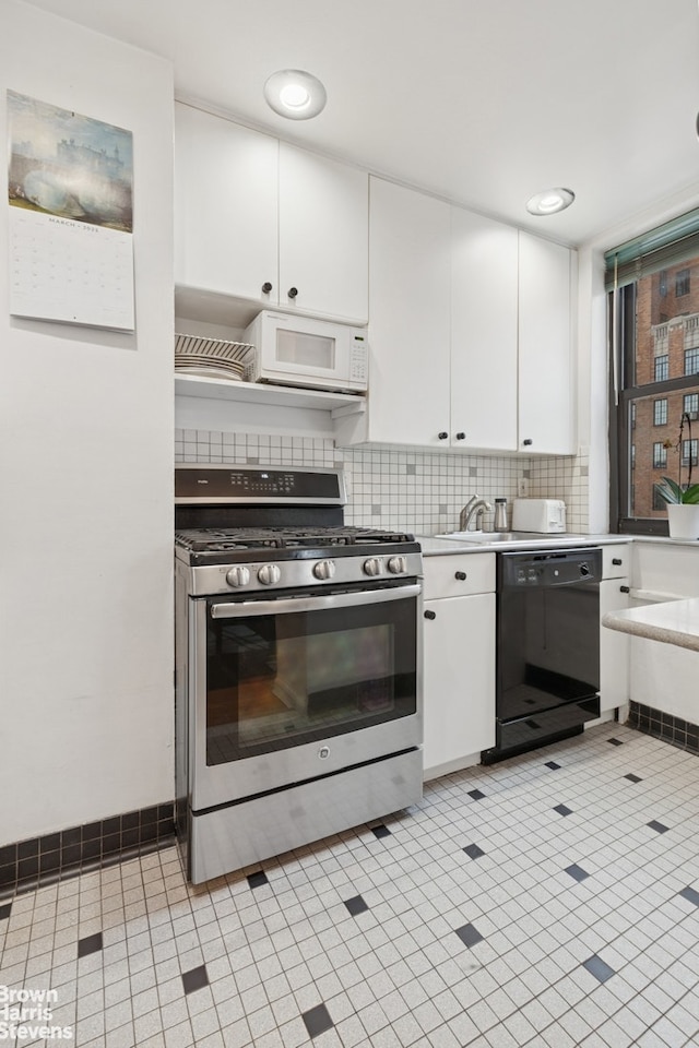 kitchen featuring stainless steel range with gas cooktop, dishwasher, white microwave, white cabinetry, and light countertops