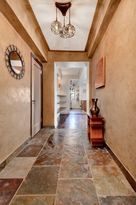 10 Park Ave Unit 12-K, New York City, NY 10016 - hall with stone tile floors, baseboards, a chandelier, and a textured wall