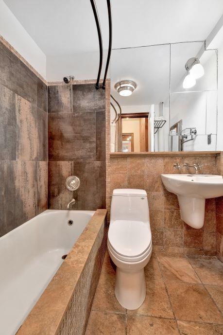 10 Park Ave Unit 12-K, New York City, NY 10016 - bathroom with tile walls, toilet, tile patterned floors, and tiled shower / bath