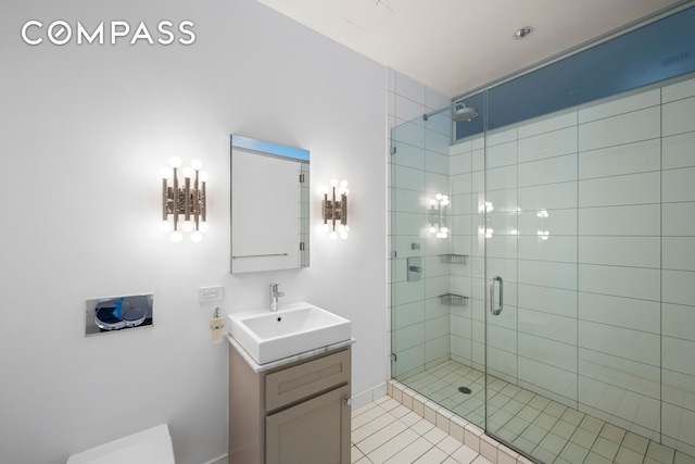 bathroom with a stall shower, vanity, tile patterned floors, and toilet