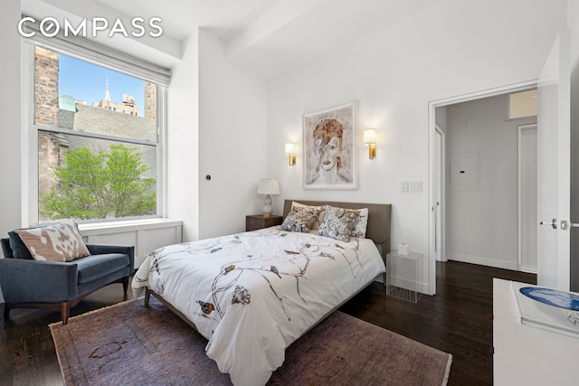 bedroom featuring dark wood-type flooring, baseboards, and electric panel