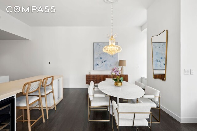 dining area featuring beverage cooler, a chandelier, wood finished floors, and baseboards