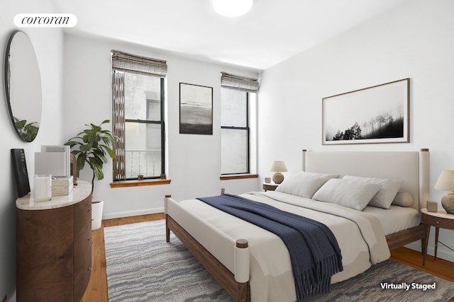bedroom with wood finished floors and baseboards