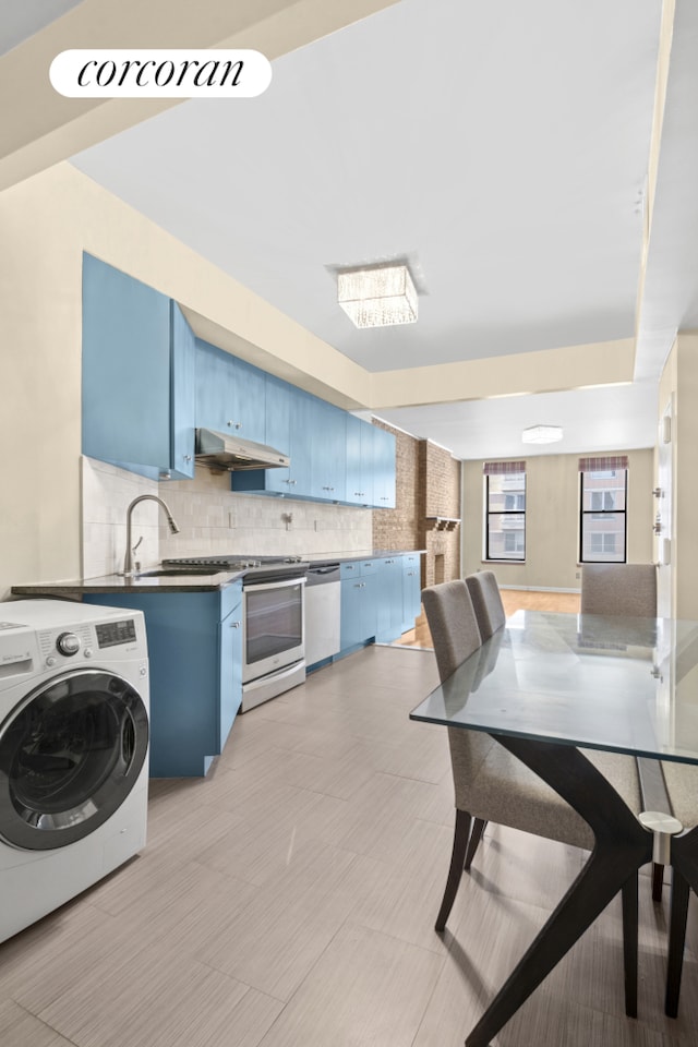 kitchen featuring blue cabinetry, washer / clothes dryer, appliances with stainless steel finishes, under cabinet range hood, and decorative backsplash