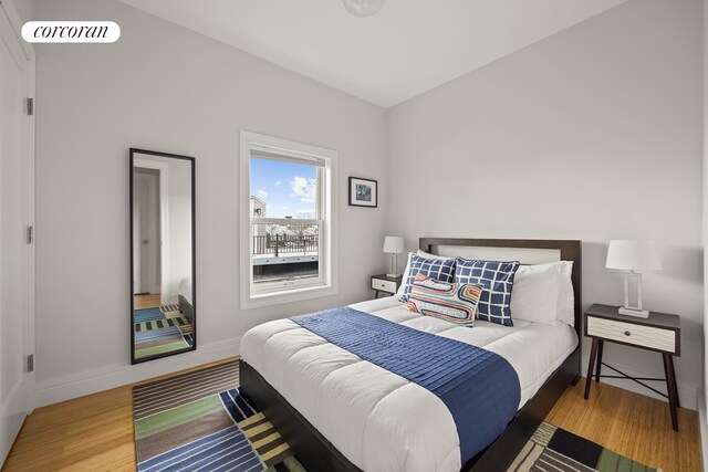 bedroom featuring baseboards, visible vents, and wood finished floors