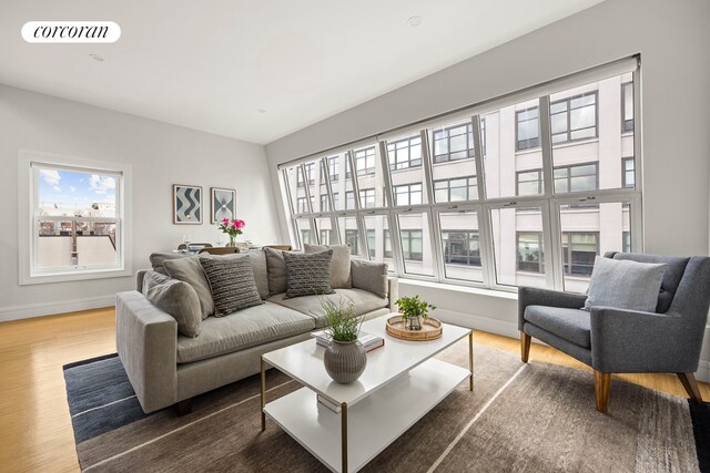 living room with visible vents, wood finished floors, and baseboards