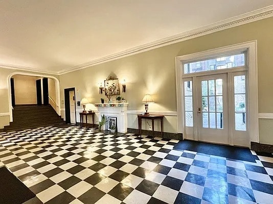 entryway with arched walkways and ornamental molding