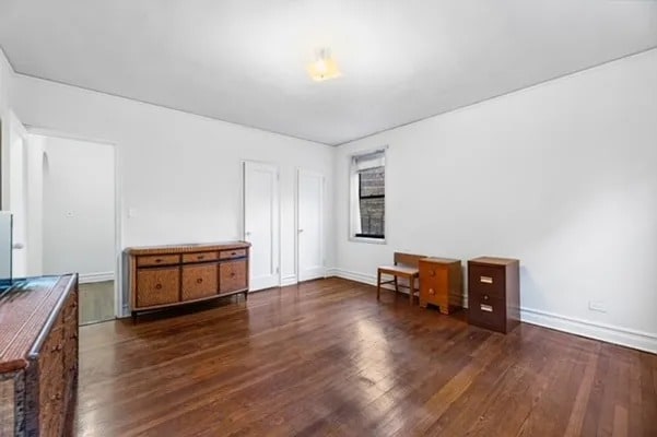 unfurnished bedroom with baseboards and wood finished floors