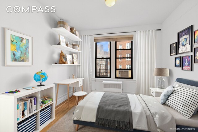 115 Cabrini Blvd Unit B51, New York City, NY 10033 - bedroom featuring radiator, wood finished floors, and cooling unit