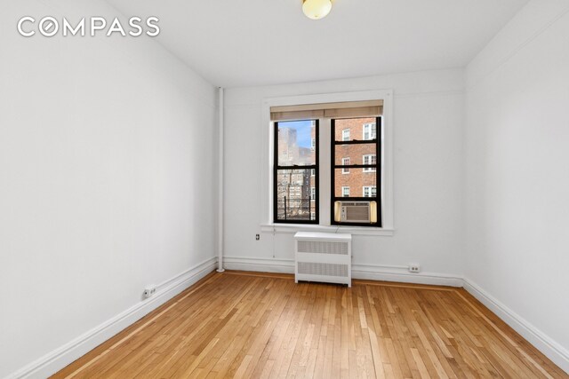 115 Cabrini Blvd Unit B51, New York City, NY 10033 - empty room featuring radiator heating unit, light wood finished floors, baseboards, and cooling unit