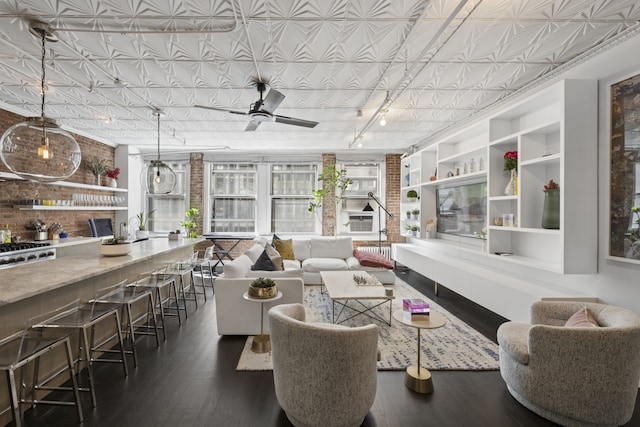 living room featuring an ornate ceiling, wood finished floors, ceiling fan, and built in shelves