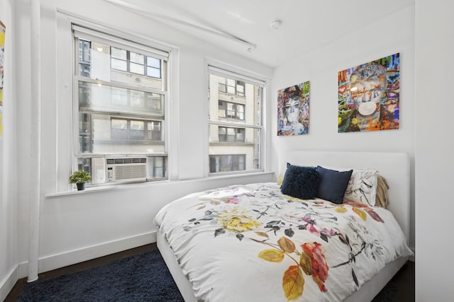 bedroom featuring baseboards and cooling unit