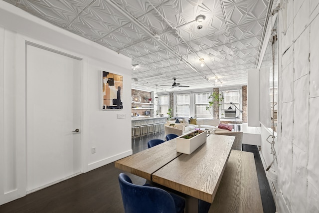 dining area with dark wood finished floors, an ornate ceiling, ceiling fan, and baseboards