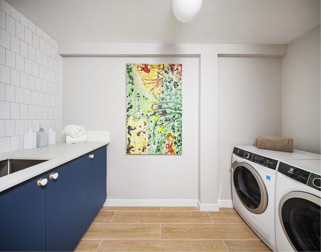 538 Henry St Unit 1, New York City, NY 11231 - washroom with washing machine and dryer, light wood-style floors, cabinet space, and baseboards