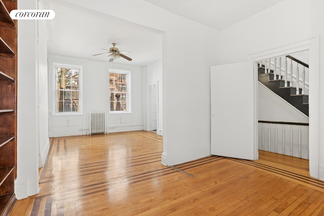 43 Charlton St, New York City, NY 10014 - unfurnished living room with radiator heating unit, hardwood / wood-style flooring, stairs, and a ceiling fan